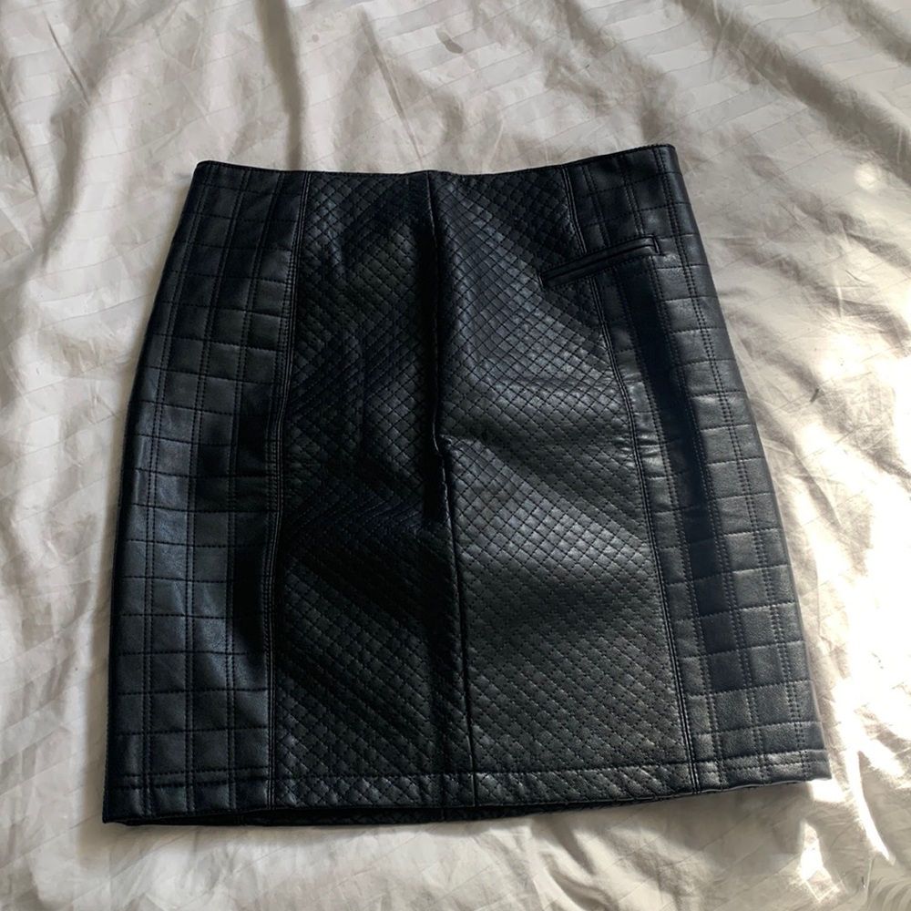 Black leather skirt with zip closure.